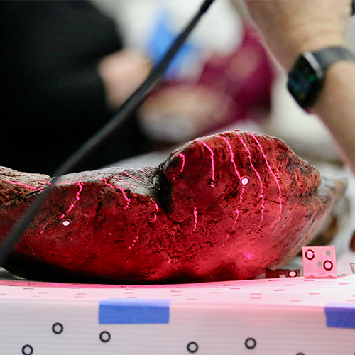 The canoe is 3D scanned by a red light passing over the surface. 